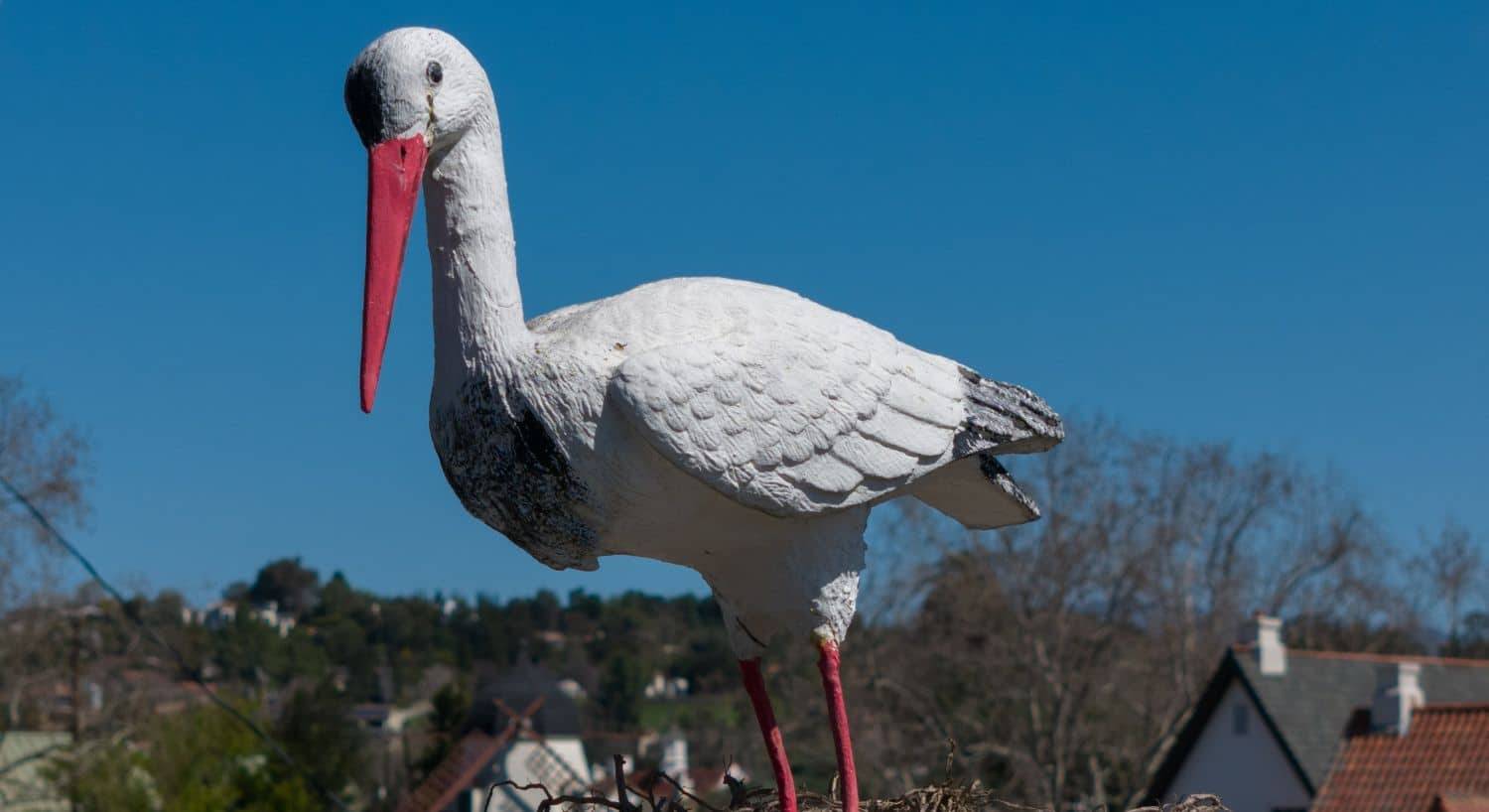A large sculpture of a white bird with a bright orange beak